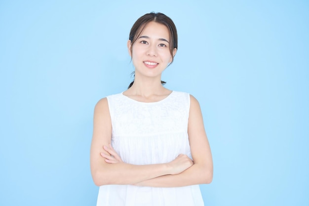 Young woman wearing sleeveless and blue background