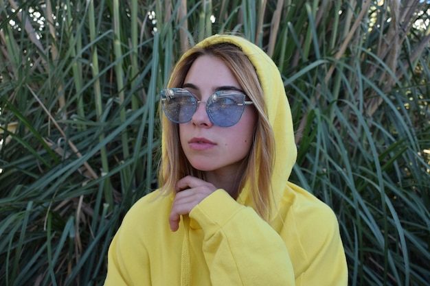 young woman wearing sunglasses against plants