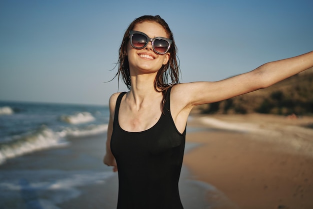 Young woman wearing sunglasses on beach against sky