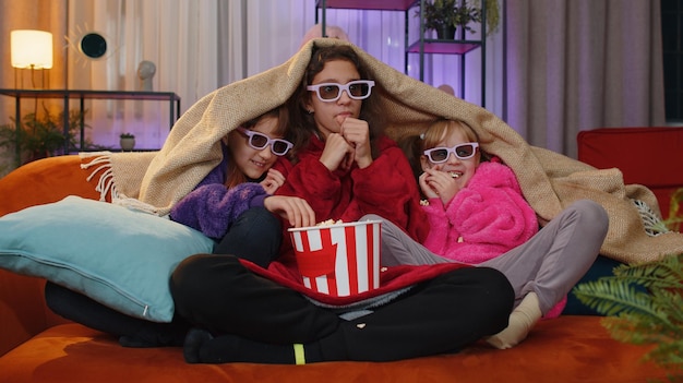 Young woman wearing sunglasses while sitting on bed at home