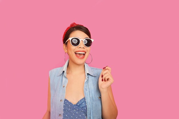 Photo young woman wearing sunglasses while standing against yellow background