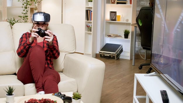 Foto giovane donna che indossa l'auricolare vr durante la riproduzione di videogiochi. fidanzato seduto sulla sedia da gioco.