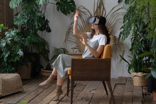 写真 vr ヘルメットをかぶった若い女性が温室で休憩しながら仮想現実を体験