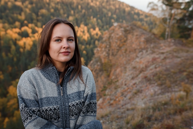 Young woman wearing a warm sweater in the mountains