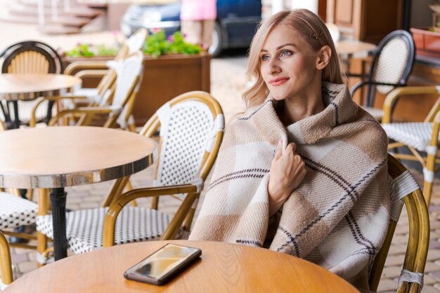 写真 街のテーブルでカフェでリラックスしている若い女性 幸せな白人女性