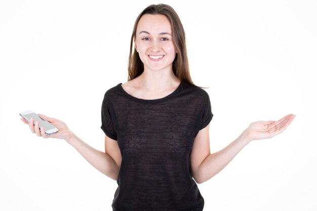 Giovane donna su sfondo bianco che mostra lo spazio vuoto della mano dello smartphone con la faccia felice