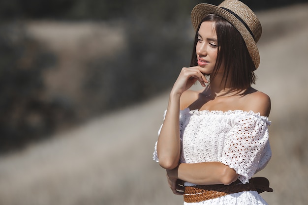 Young woman in a white dress and hat