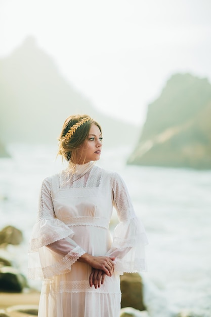 young woman in white dress walking at the beach