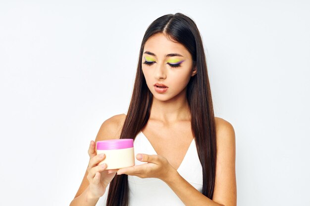 Young woman in a white jersey jar with cosmetics isolated background unaltered