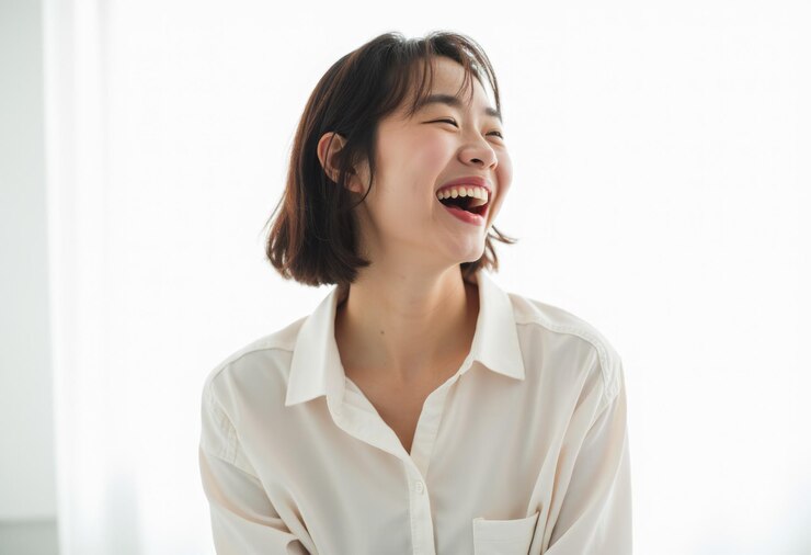 Photo  셔츠 를 입은 젊은 여자 가 머리 를 뒤로 기울여 기게 웃고 있다