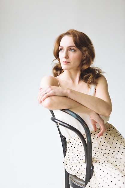 Young woman in white shirt and skirt on white background