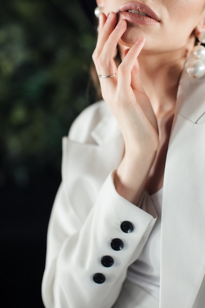 Young woman in a white suit and a black hat