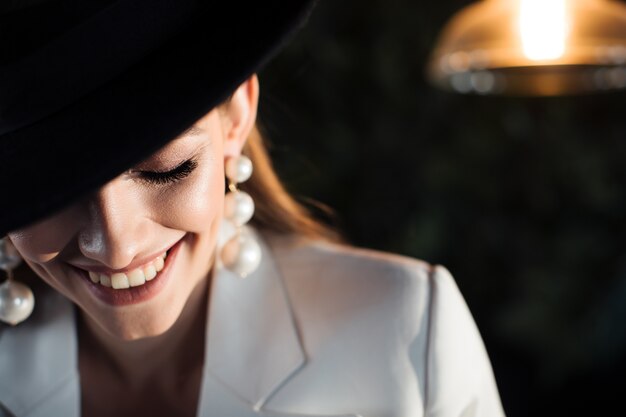 Young woman in a white suit and a black hat