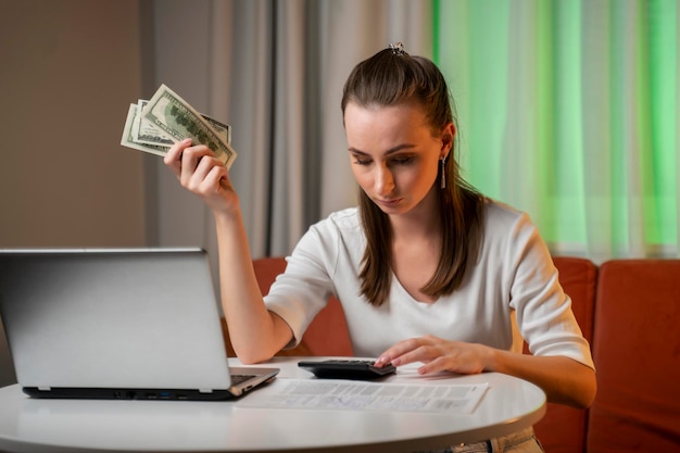 A young woman who is in a state of stress calculates monthly housing costs and installments for a ca