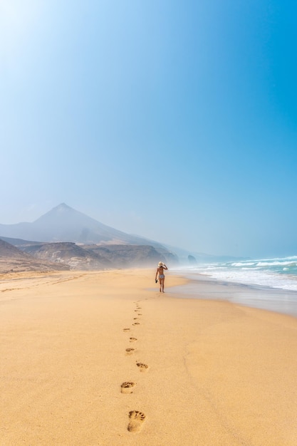 A young woman on the wild beach Cofete of the natural park of Jandia Fuerteventura