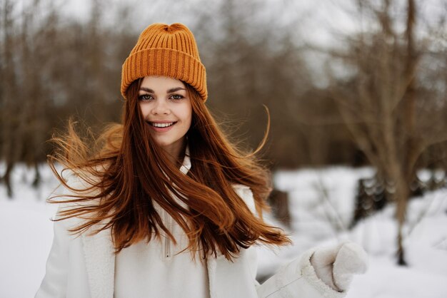 Young woman in winter clothes in a hat fun winter landscape\
there is a lot of snow around high quality photo