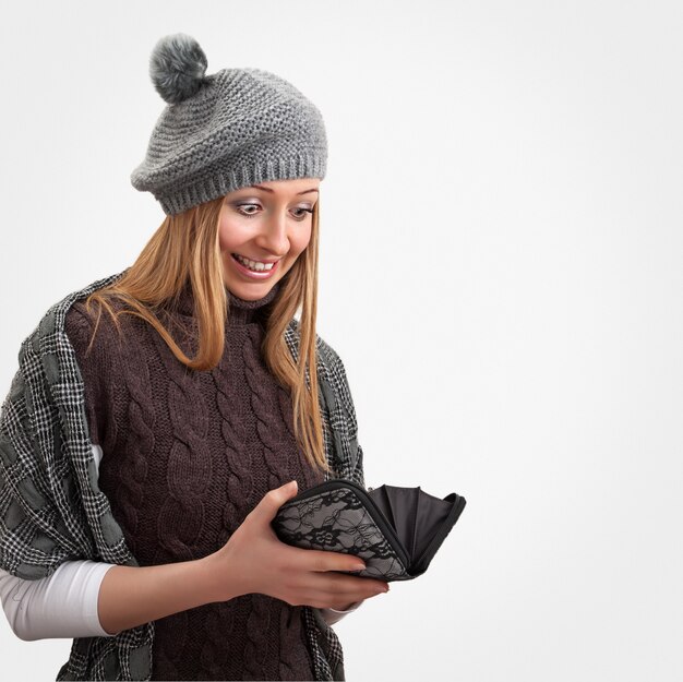 Young woman in winter clothes looking in wallet