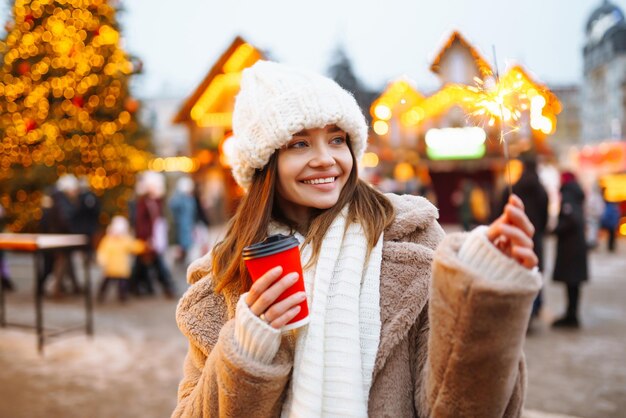 Foto giovane donna in abiti da inverno che posa al mercato di strada festivo donna che si gode i momenti invernali