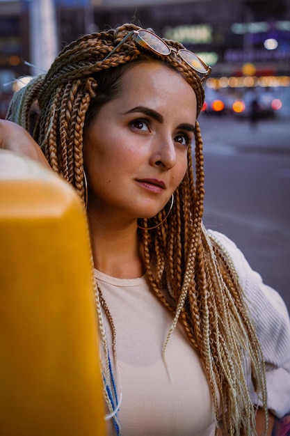 Photo young woman with afro zizi braids and bright makeup in a big city, portrait. zizi braids hairstyles.