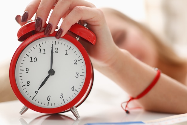 Young woman with alarm clock