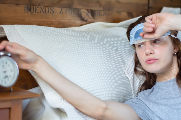 Young woman with alarm clock