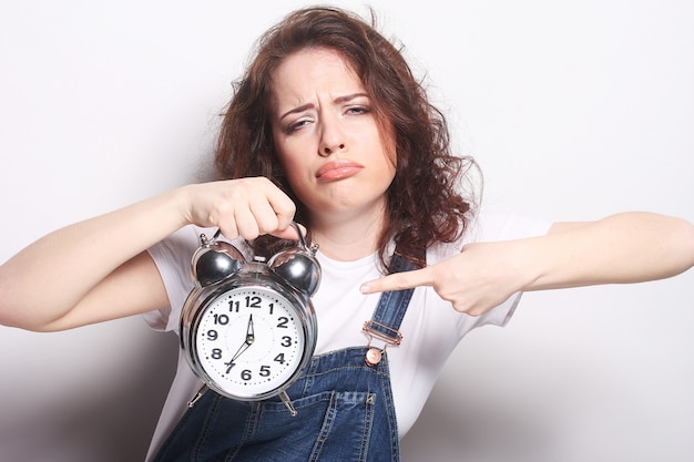 Young woman with alarmclock