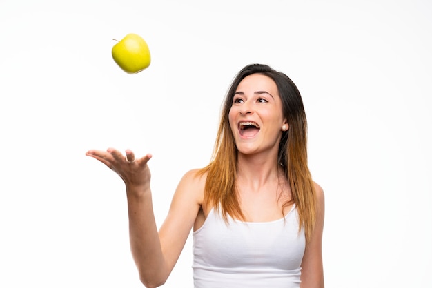 Young woman with an apple over isolated white wall