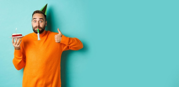 Young woman with arms raised against blue background