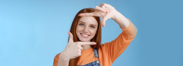 Foto giovane donna con le braccia alzate contro uno sfondo blu