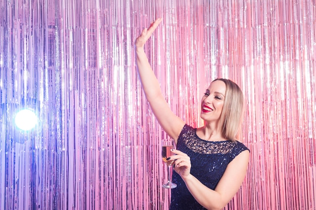 Photo young woman with arms raised standing against illuminated background