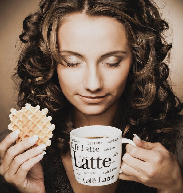 Young woman with an aromatic coffee in hands