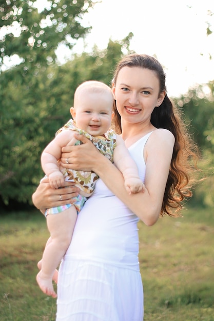 Young woman with a baby on a background of city Park