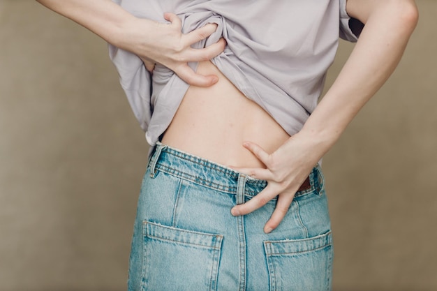 Young woman with back spine pain ache against brown background