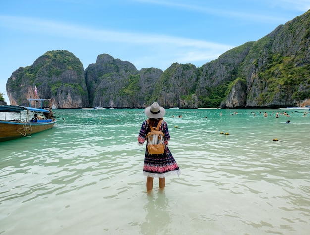 La giovane donna con lo zaino gode sulla riva nella baia di maya, isola di phi phi