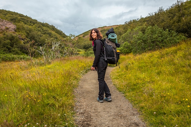 A young woman with a backpack starting the 4-day trek from Landmannalaugar. Iceland