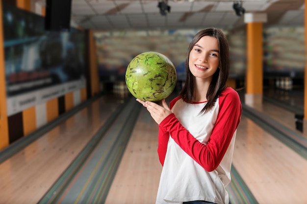 Giovane donna con la palla nel club di bowling