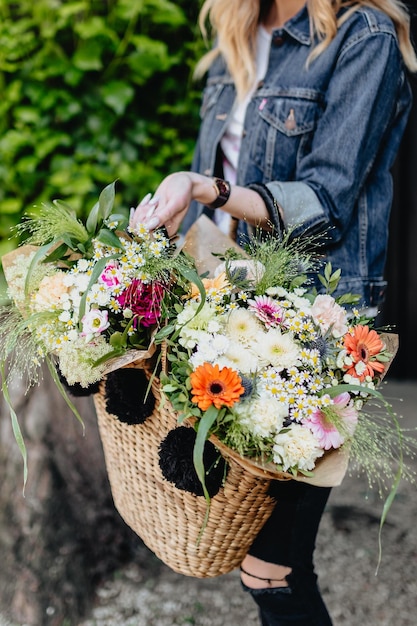 Giovane donna con cesto pieno di fiori