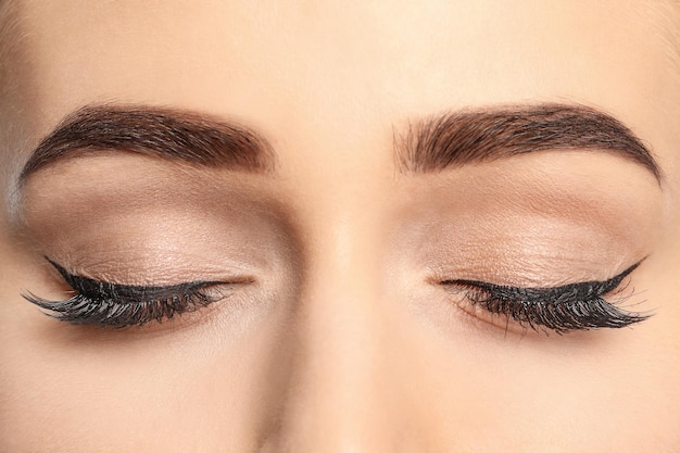 Young woman with beautiful eyebrows after correction closeup