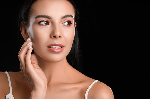 Young woman with beautiful eyeshadows on dark