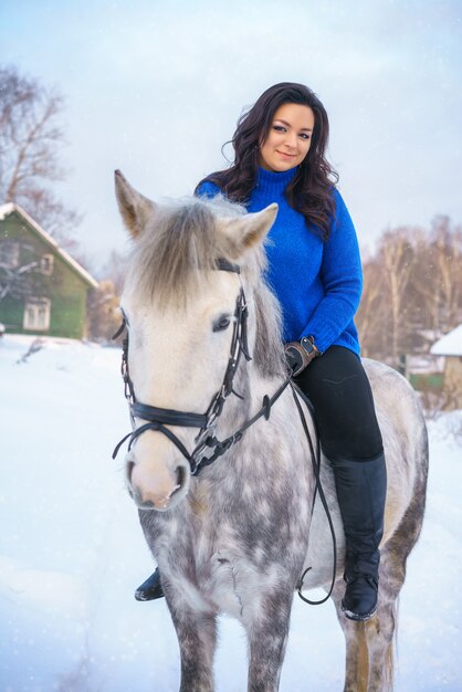 A young woman with a beautiful winter white horse