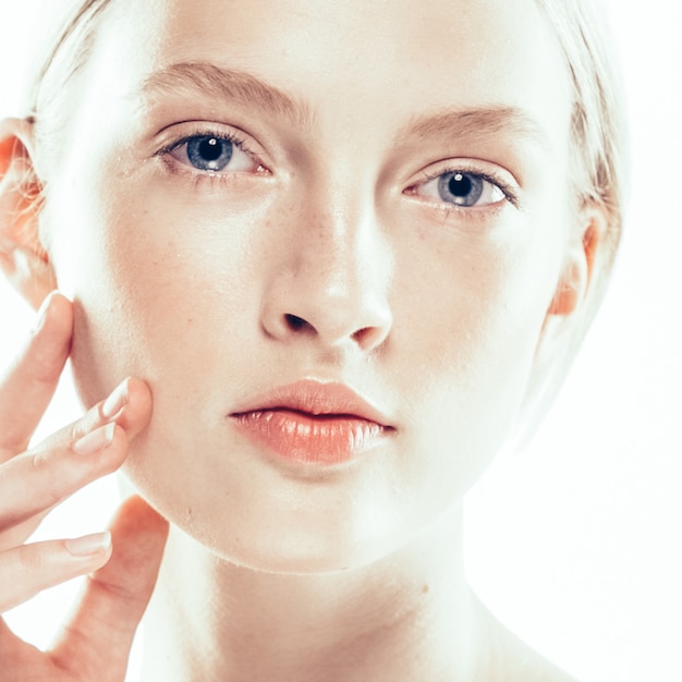 Foto giovane donna con la pelle di bellezza e l'acconciatura di bellezza mano toccando il viso isolato su bianco