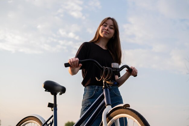 Photo young woman with bicycle against sky