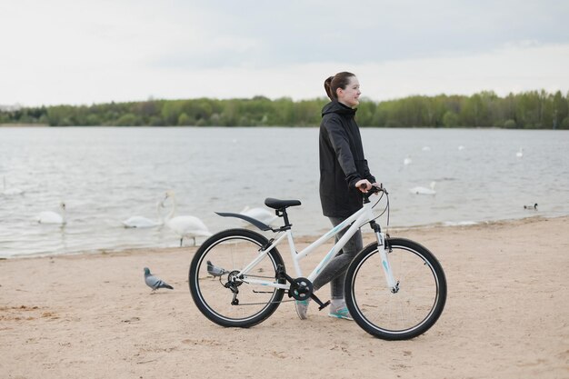 湖で自転車を持っている若い女性