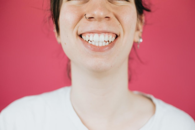 Giovane donna con un grande sorriso che sorride alla telecamera con sfondo colorato e spazio per la copia atteggiamento felice e divertente salute mentale e prendersi cura di se stessa concetto sii felice sorriso denti bianchi