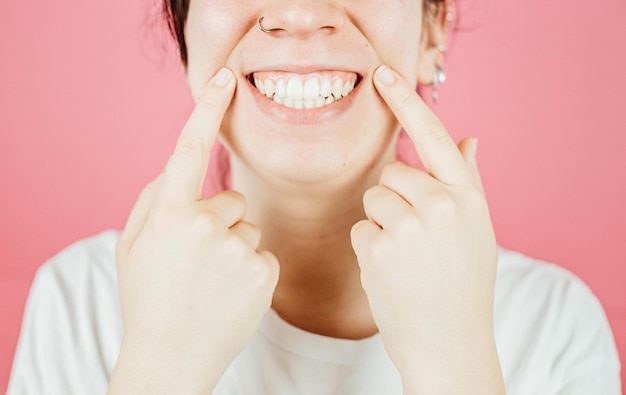 Young woman with big smile smiling to camera with color background and copy space Happy and fun attitude mental health and taking care of herself concept Be happy smile white teeth