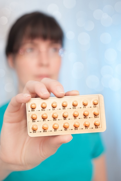 Young woman with birth control pills 