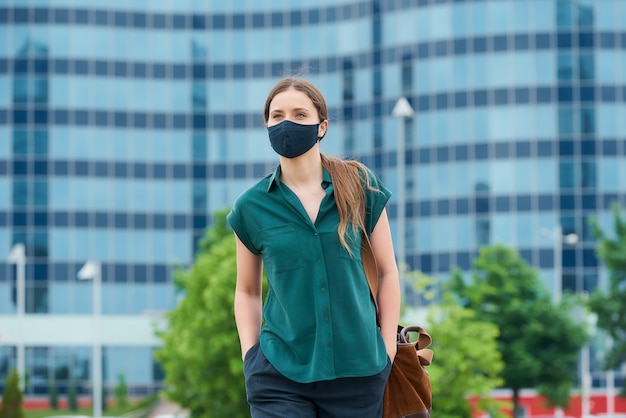 Young woman with a black face mask in the city