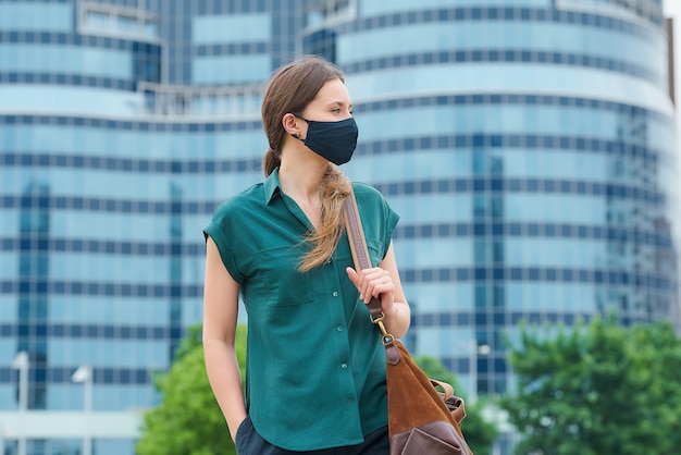 Young woman with a black face mask in the city