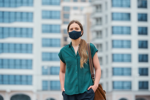 Young woman with a black face mask in the city