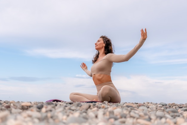 Young woman with black hair fitness instructor in leggings and tops doing stretching and pilates on